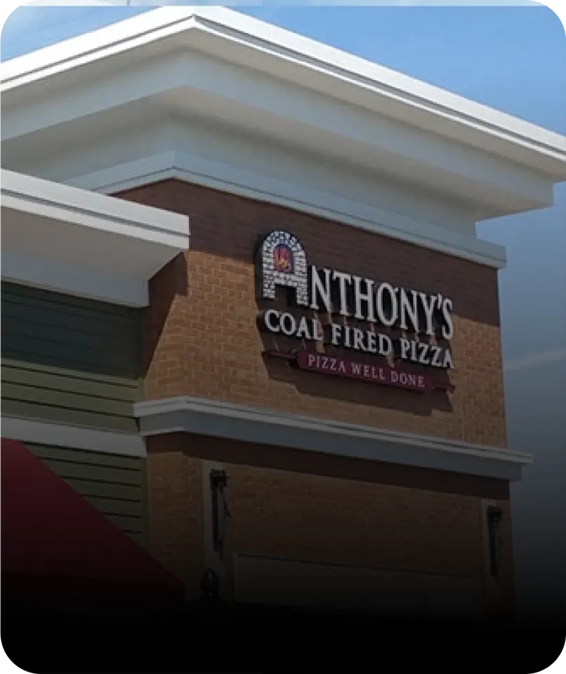 Exterior view of Anthony’s Coal Fired Pizza in Plantation, with the restaurant’s signature logo clearly visible on the building.