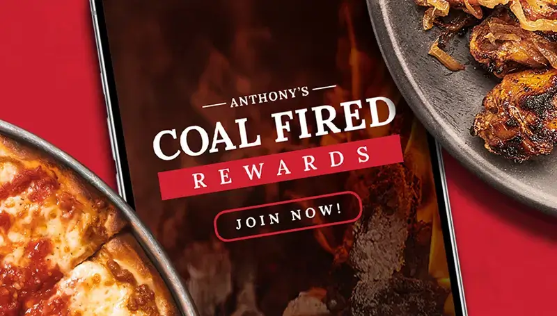 Close-up of Anthony’s Coal Fired Rewards card next to pizza and wings, promoting the sign-up offer of a free pizza and rewards points.