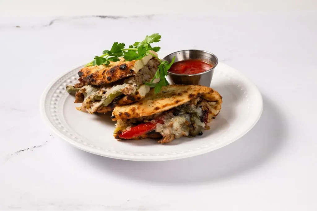 Italian sausage and sautéed peppers on fresh bread at Anthony’s, bold Italian food with coal fired flavor in every bite.