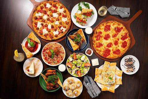 Game-day spread with coal-fired pepperoni and sausage pizzas, wings, pasta, garlic knots, and Italian desserts from Anthony’s.
